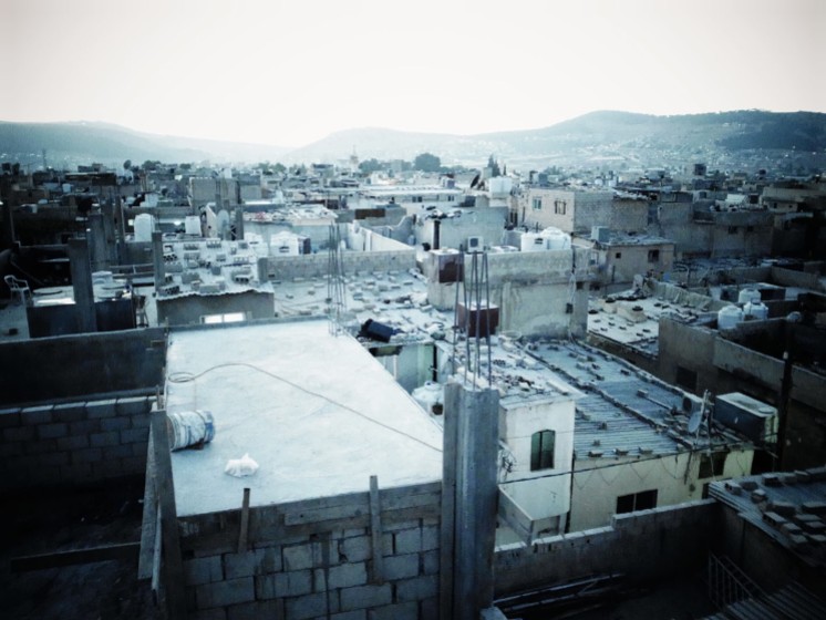 A birds' eye view of Baqa'a camp's (Jordan) density today. Refugees often maintain zinc roofing on their top floors, to be able to expand vertically once means allow. (c) S. Maqusi. 2014.
